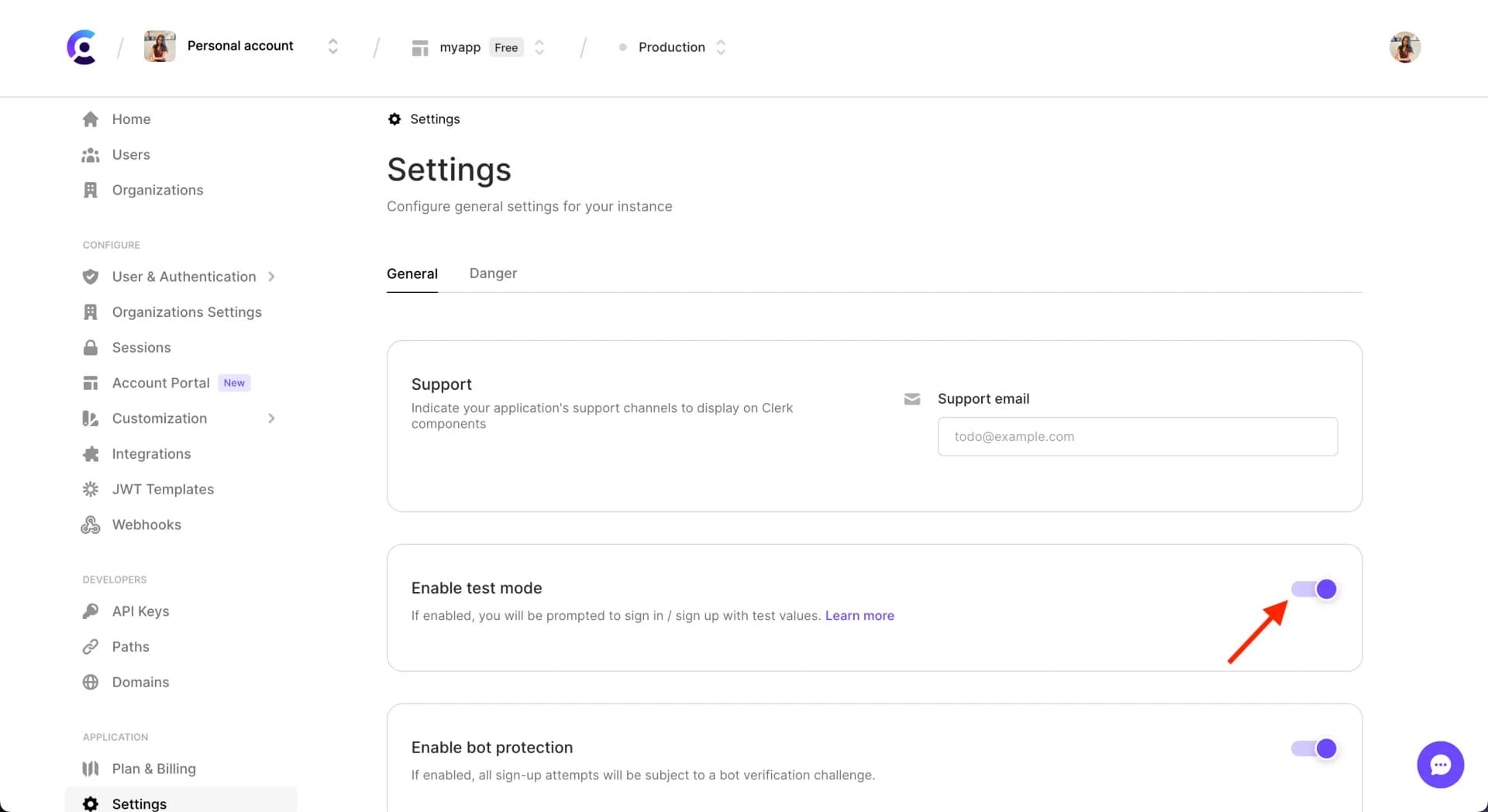 The 'Enable test mode' section of the Settings page in the Clerk Dashboard. There is a red arrow pointing to the toggled, which is toggled on.